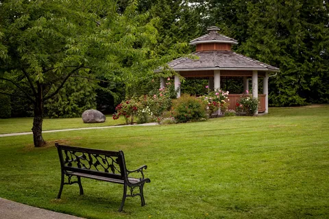 Garden with a wooden gazebo, lawn and a bench