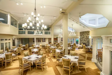 Dining room with set tables, wooden chairs and chandeliers