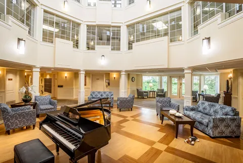 Atrium lounge with patterned sofas, armchairs and a grand piano