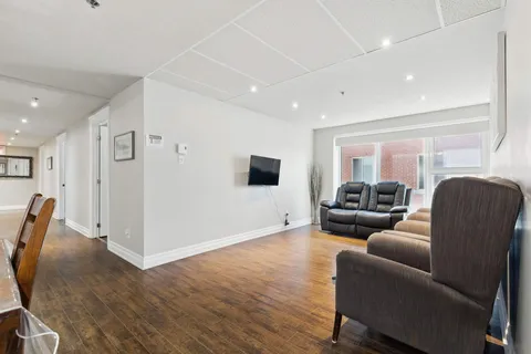 Sitting area with reclining armchairs, a television and a wide window