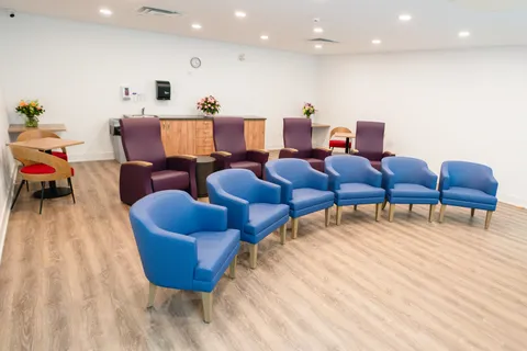 Activity room with chairs arranged in rows and an upright piano.