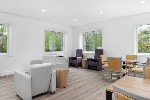 Sitting room with sofas, tables and large windows.