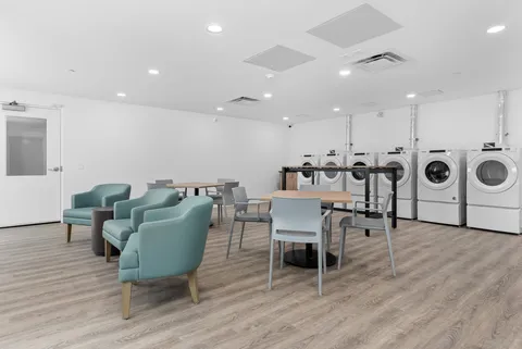 Salon area with styling chairs, wash basins and laundry machines.