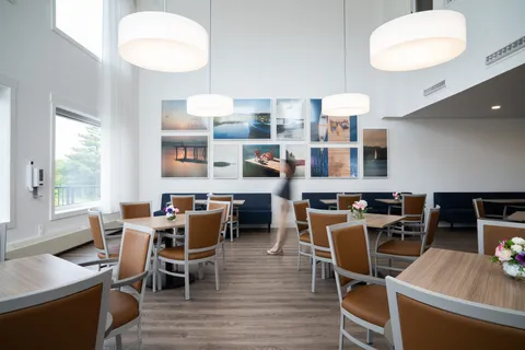 Dining room with tables, chairs, pendant lights and a service counter.