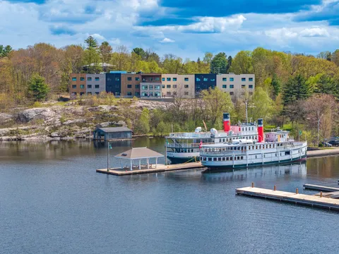 Residence beside the waterfront, with a boat and docks in the foreground.