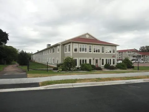 Two-storey residence with a lawn and paved path beside the street.