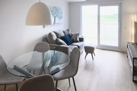 Suite living room with a sofa and round glass dining table.
