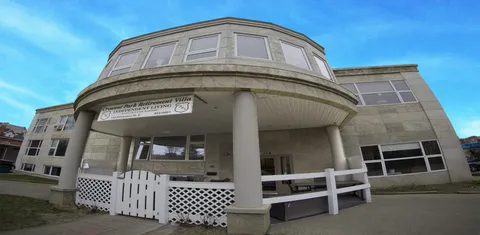Building entrance with a rounded canopy, white columns and railings