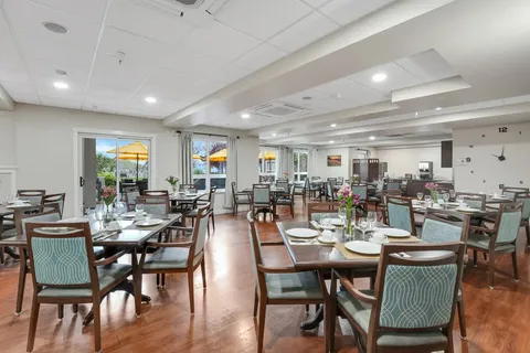 Dining room with set tables, patterned chairs and large windows