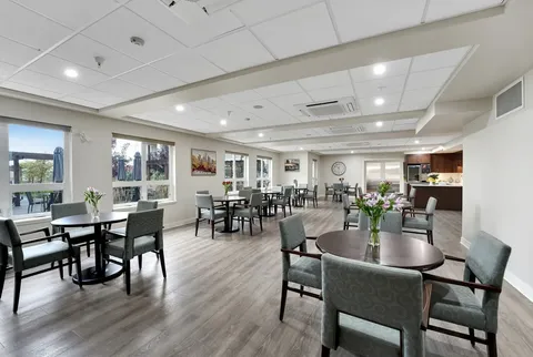 Room with round tables, upholstered chairs and a service counter