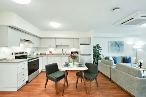 Kitchen and sitting area with a small dining table and a grey sofa