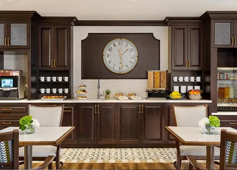 Bistro tables and chairs beside a counter and wall clock.