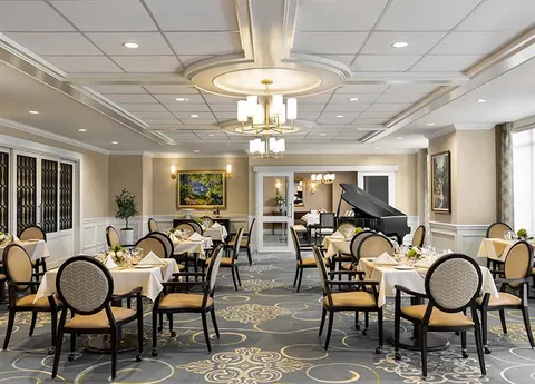 Dining room with set tables and a grand piano.