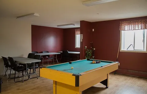 Games room with a pool table, tables, chairs and windows