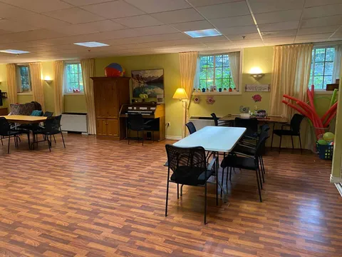 Room with tables, chairs, an organ and exercise equipment