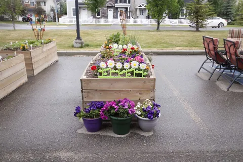 Raised flower beds and potted flowers beside outdoor seating
