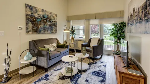 Sitting area with a sofa, armchair, coffee tables and a television
