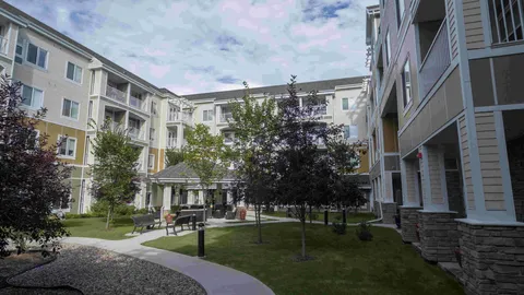 Residential building surrounding a courtyard with lawns, trees and paths