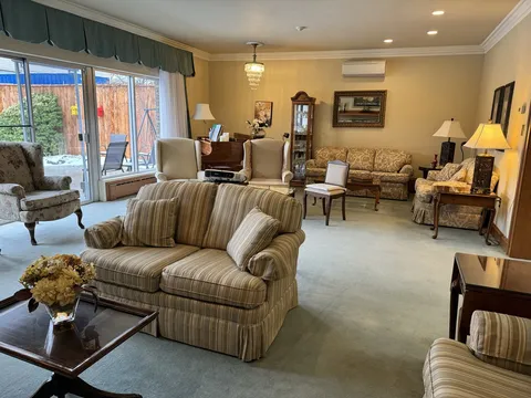 Room with sofas, armchairs, large windows, mirrors and a piano