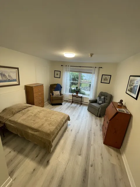 Bedroom with a bed, wooden furniture and framed landscape pictures
