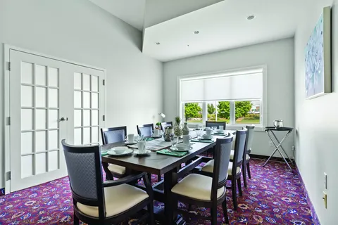 Small dining room with a set table and upholstered chairs