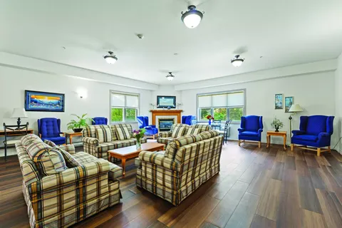 Sitting room with plaid chairs, blue armchairs and a fireplace