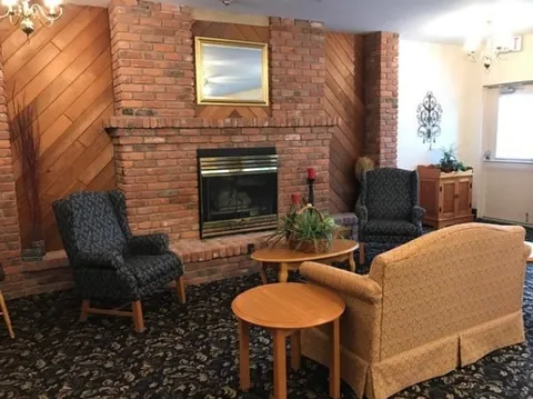 Lounge with armchairs around a brick fireplace.