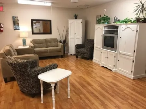 Suite living area with a sofa, armchairs and television cabinet.