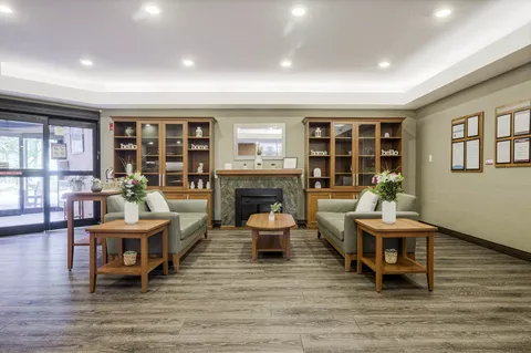 Seating area with sofas, tables and a fireplace between display cabinets