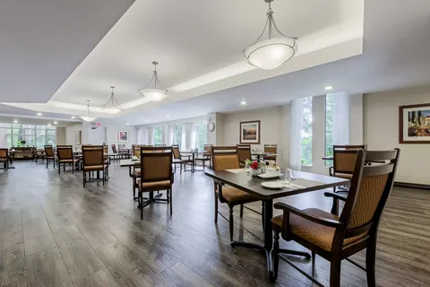 Dining room with square tables, upholstered chairs and pendant lights