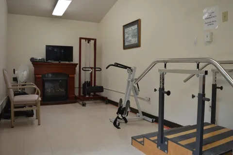 Exercise room with parallel bars, a stationary bicycle and a television