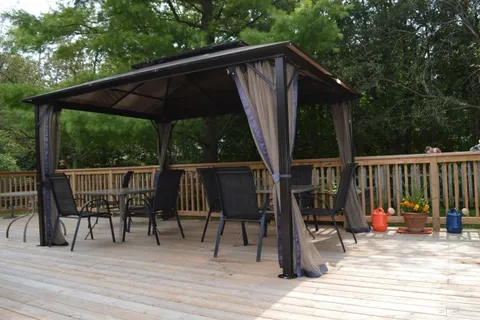 Wooden deck with a gazebo and outdoor tables