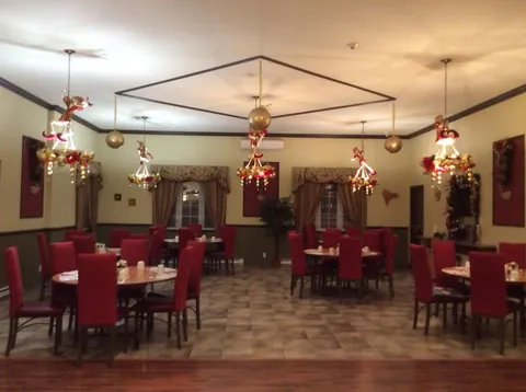 Dining room with tables, chairs and hanging seasonal decorations.