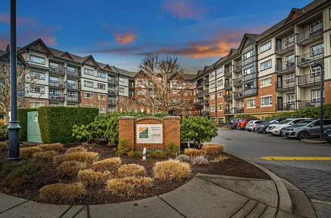 Residence wings and landscaped entrance courtyard beneath a colourful evening sky