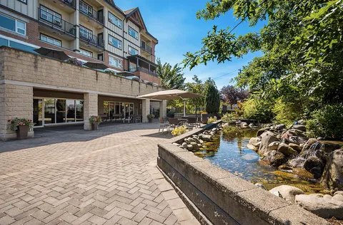 Paved patio and pond beside the residence and garden beds