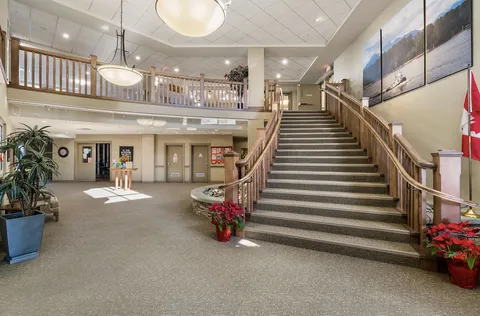 Lobby with a broad staircase, wooden railings and large river pictures