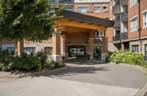 Covered entrance with brick columns and a paved driveway