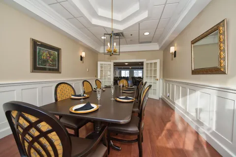 Private dining room with a long table and upholstered chairs.