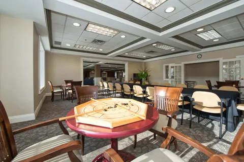 Games area with a crokinole board, tables and chairs.