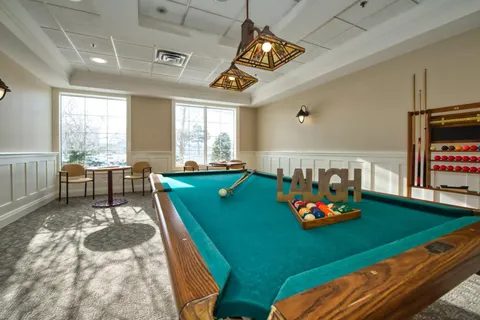 Games room with a billiards table and large windows.