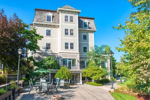 Residence building beside an outdoor patio and planted beds.