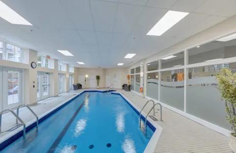 Indoor swimming pool with handrails and windows
