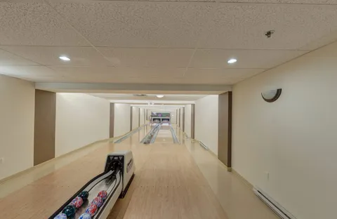 Indoor bowling lanes with bowling balls on a return rack
