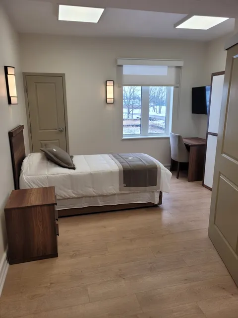 Bedroom with a bed, desk and wardrobe.