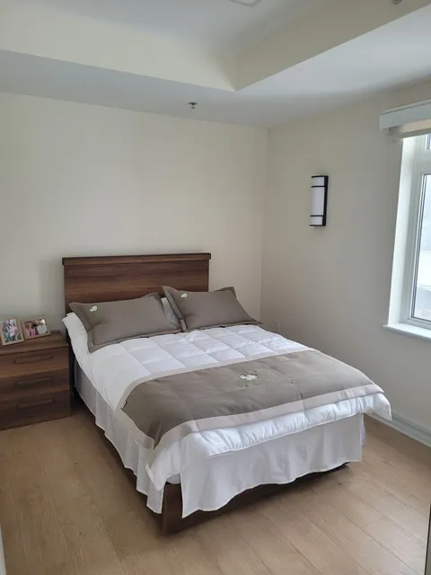 Suite bedroom with a bed and bedside table.