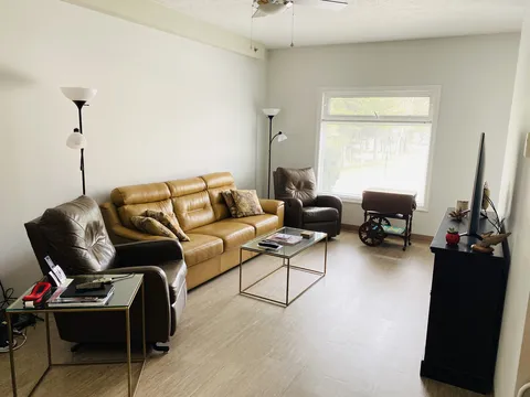 Suite living room with a sofa, armchairs, coffee table and television.