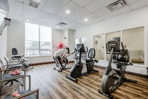 Exercise room with stationary bicycles, chairs and dumbbells