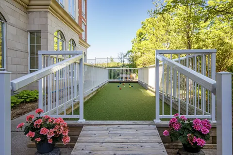 Bocce court with railings and flower planters beside the building