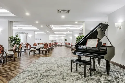 Grand piano beside tables and chairs in a dining room
