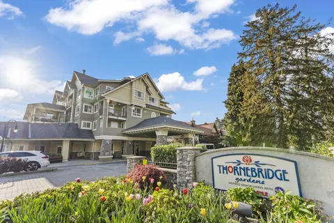 Building with balconies, a covered entrance and flower beds